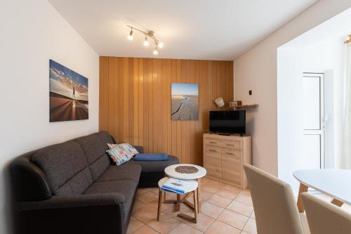 a living room with a couch and a table at Haus Windböe, Wohnung 3 in Duhnen