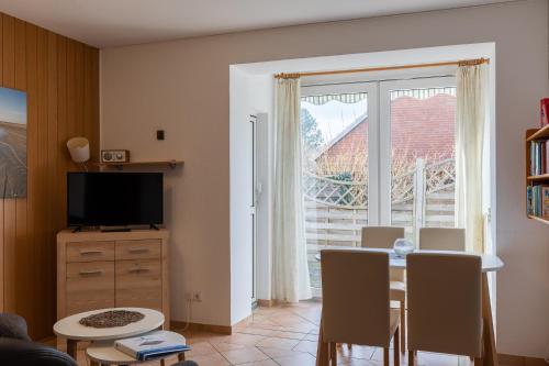 a living room with a table and a window at Haus Windböe, Wohnung 3 in Duhnen
