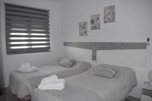 two twin beds in a room with a window at La Jara Rosa in Los Navalucillos