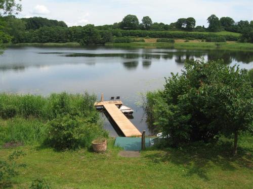 a dock on a lake with a boat on it at Ferienhaeuser Poenitz am See in Klingberg