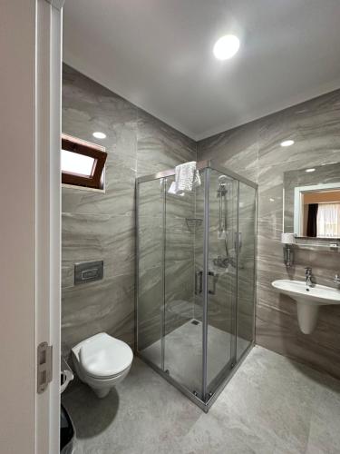a bathroom with a shower and a toilet and a sink at Midas Pension in Dalyan