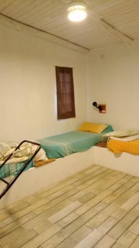 a bedroom with two beds and a wooden floor at Casa Quinta Doña María in Concepción del Uruguay