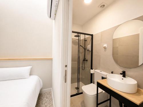 a white bathroom with a sink and a shower at Hostal Majadahonda in Majadahonda