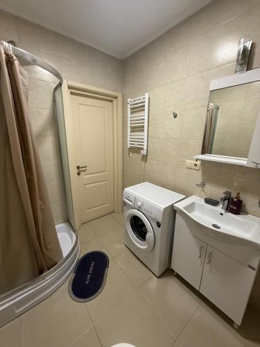 a bathroom with a washing machine and a sink at Apartment on Angisa, 78 in Batumi