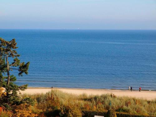 two people standing on a beach near the ocean at Pension Radke in Heringsdorf