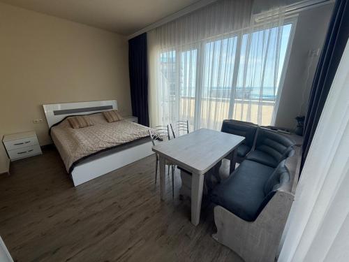 a bedroom with a bed and a table and chairs at Apartment on Angisa, 78 in Batumi