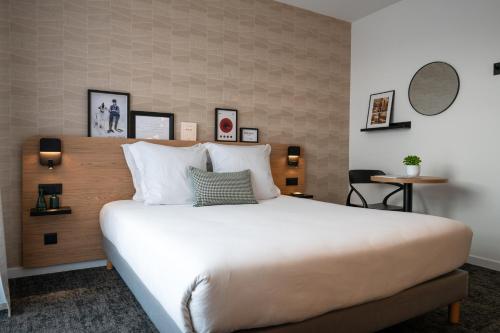 a bedroom with a large white bed in a room at Nemea Appart Hotel Sunset Nice Arenas in Nice