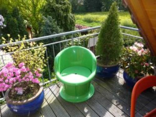 a green toilet sitting on a deck with potted plants at 4_Zimmer_Ferienwohnung in Wathlingen