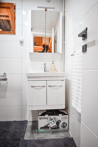 a white bathroom with a sink and a mirror at Etno kuca Drina in Loznica