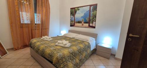 a bedroom with a bed with two towels on it at Casa Nicole - Letojanni Taormina in Letojanni