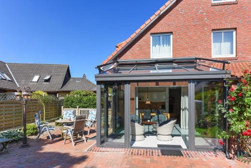 an extension of a house with a conservatory at Ferienhaeuser Deichkrone in Bensersiel