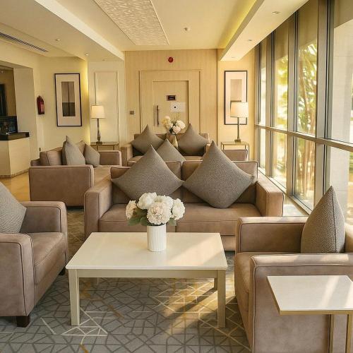 a living room with couches and a vase of flowers at شقق الشرفة للشقق المفروشة -AlSHORFA FURNISHED APARTMENT in Riyadh