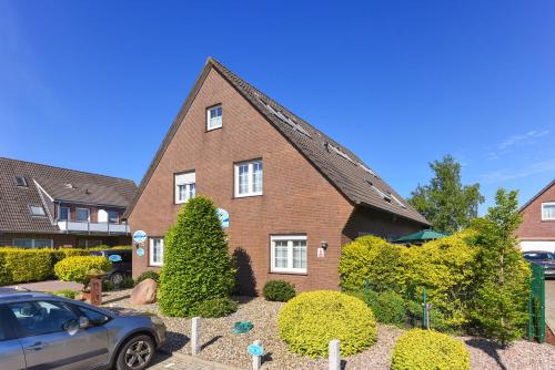 a house with a car parked in front of it at Haus Nordseesterne in Bensersiel