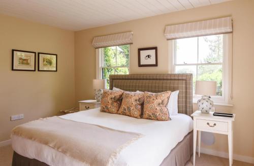 a bedroom with a large bed and two windows at The Three Daggers in Edington