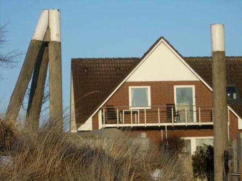 a house with a deck on the side of it at Strandhaus Buchtmitte in Haffkrug