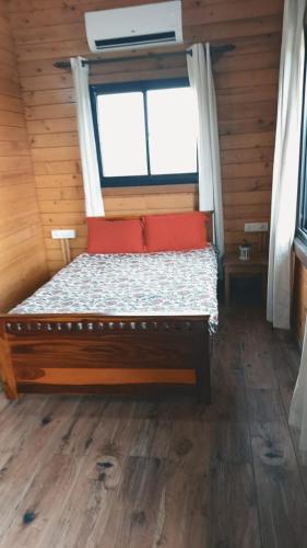 a bed in a wooden room with a window at Wonderville Villa in Cuncolim