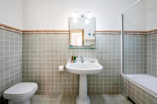 a bathroom with a sink and a toilet and a mirror at Villa Balata di Modica con piscina privata in Ragusa
