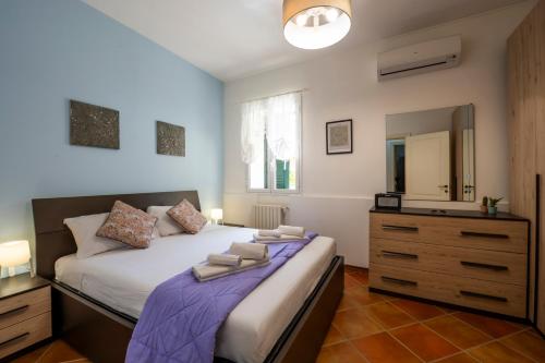 a bedroom with a bed with a dresser and a mirror at Villa Balata di Modica con piscina privata in Ragusa