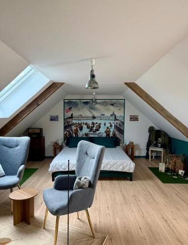 a bedroom with a bed and two chairs at Comme en 40 in La Lande-sur-Drôme