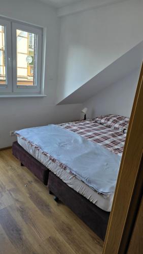 a large bed in a room with a window at Apartament Riva in Rowy