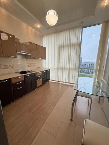 a kitchen with a glass table and a large window at Квартира Марсельська in Kryzhanivka