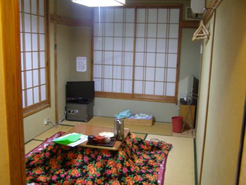 una sala de estar con mesa de centro en una habitación en Kadowakikan en Nozawa Onsen