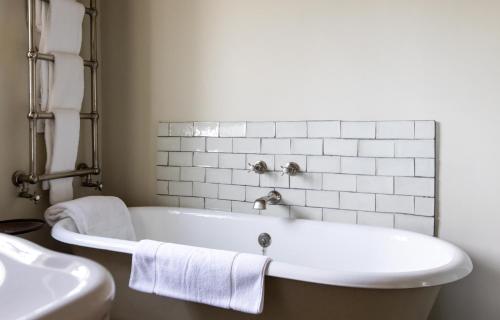 a white bath tub in a bathroom with a sink at The Three Daggers in Edington