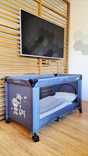 a blue baby crib with a television on a wall at BLACKWOOD Kitchen in Bratislava