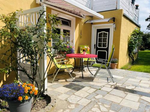 a patio with a table and chairs in front of a house at Rosenhof Ferienwohnungen in Mölln-Medow
