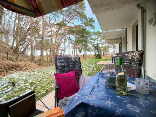 a table with two chairs and a bottle of wine at Haus Meeresblick - Ferienwohnung Ostseeperle A 0.13 (Ref. 128670) in Baabe