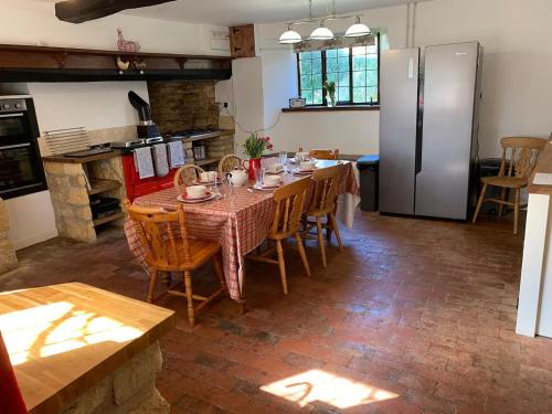 a kitchen with a table with chairs and a refrigerator at 6 Bedroom Farm House with 12 Beds in Weldon in Weldon