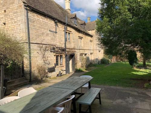 a wooden picnic table in front of a building at 6 Bedroom Farm House with 12 Beds in Weldon in Weldon