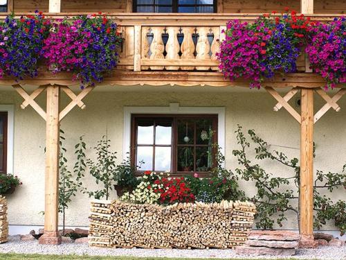 a house with flowers on a balcony with a window at Primushäusl Gästehaus in Strobl