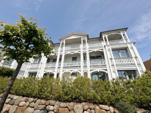 a large white house with a tree in front of it at Villa Annika - Whg 06 in Ostseebad Sellin