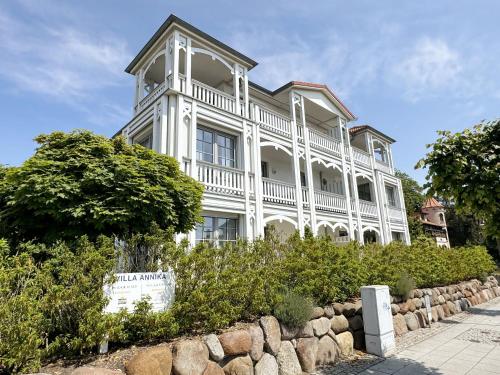a large white house with a tree in front of it at Villa Annika - Whg 06 in Ostseebad Sellin