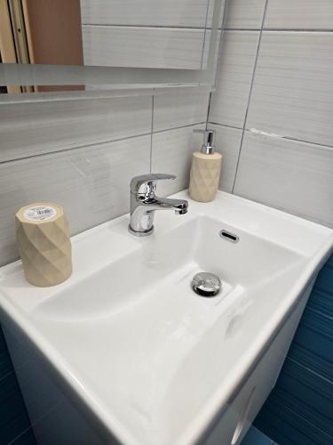 a bathroom sink with a faucet and a roll of toilet paper at Hotel Natali 2 in Dhërmi