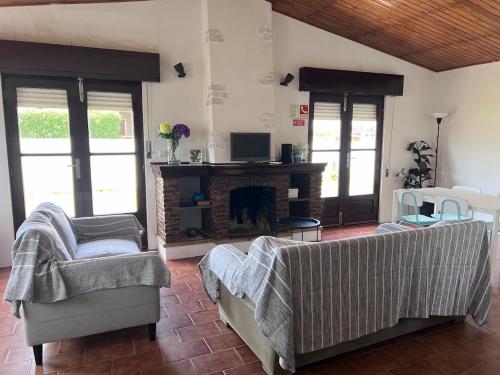 a living room with two couches and a fireplace at Pinho Azul - Beach House in Apúlia