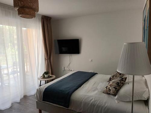 a bedroom with a bed with a lamp and a television at DOMITYS - L'Edito in Amiens