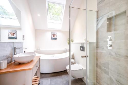 a bathroom with a tub and a sink and a shower at 4 Bed in Taunton oc-w35167 in West Monkton