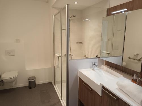 a bathroom with a shower and a sink and a toilet at DOMITYS - L'Edito in Amiens