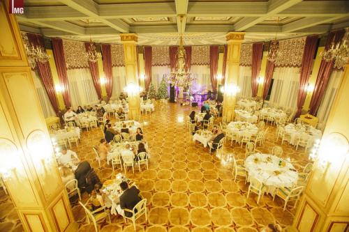 a large banquet hall with white tables and chairs at Hotel Intourist Palace Batumi in Batumi