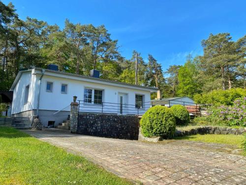 an old white house with a stone driveway at Ferienhaus Hete in Staphel