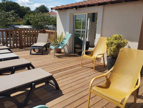 a wooden deck with chairs and tables on it at Camping les Acacias in Fréjus