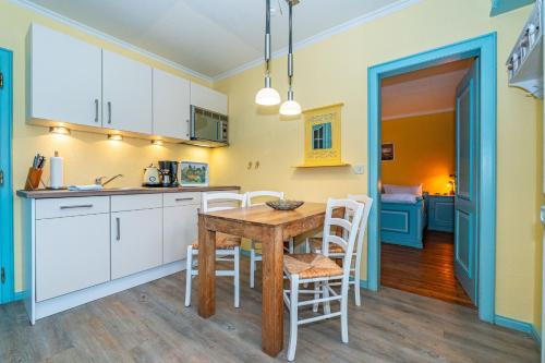 a kitchen and dining room with a table and chairs at Priel-Hüs in List