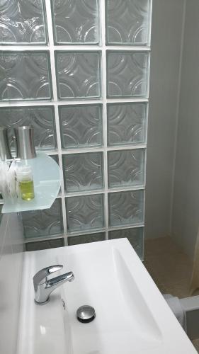 a bathroom with a white sink and glass shelves at Pensiunea Iris in Săcele