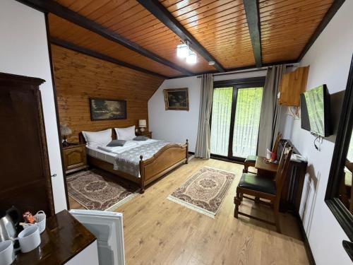 a bedroom with a bed and a wooden ceiling at Pensiunea Eugenia in Bran