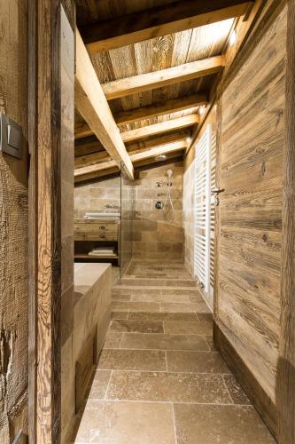 a bathroom with wooden walls and a walk in shower at Le Chalet Blanc in Megève