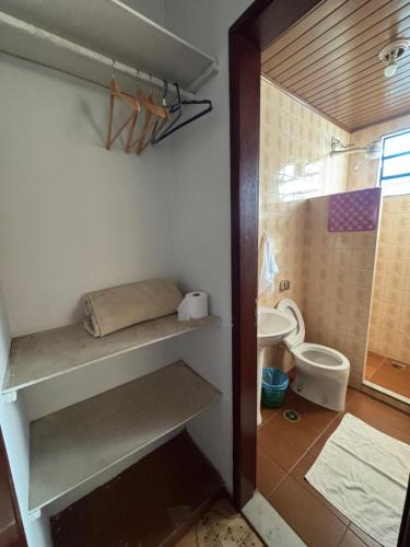 a bathroom with shelves and a toilet in a room at Pousada famíliar no Centro com café da manhã incluso in São Lourenço