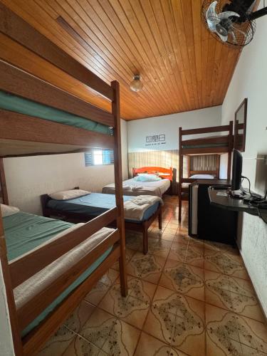 a room with three bunk beds and a table at Pousada famíliar no Centro com café da manhã incluso in São Lourenço