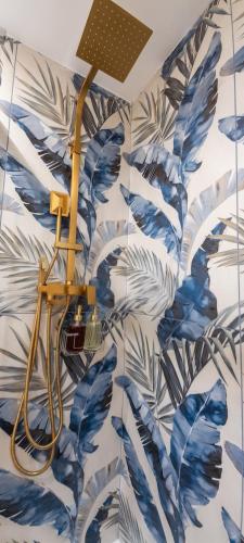 a bathroom with blue and white leaves wallpaper at Casa Linda Affitacamere Rozzano HUMANITAS FORUM ASSAGO M2 MILANO Centro IEO in Rozzano